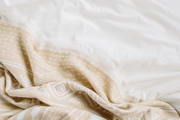 White bedding with warm plaid. Cozy background with copy space. Scandinavian style.  Flat lay, top...
