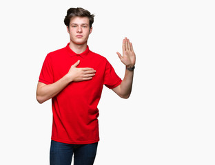 Young handsome man wearing red t-shirt over isolated background Swearing with hand on chest and...