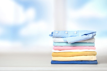 Stack of colorful clothes on empty space background.