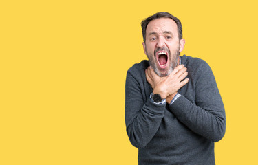 Handsome middle age senior man wearing a sweater over isolated background shouting and suffocate because painful strangle. Health problem. Asphyxiate and suicide concept.