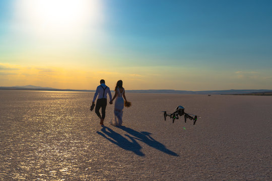 Luxury and futuristic wedding photography and videography. Hovering drone taking pictures of wedding couple at Salt Lake, Sereflikochisar, Turkey.