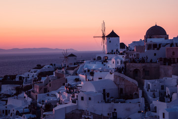 The white village of Oia, on the island of Santorini, Greece during a romantic red sunset in the...