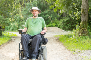 Portrait photo of a handicapped man in a electric wheelchair in nature