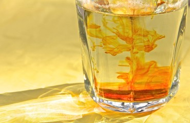 Glass with orange paint drops