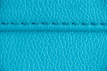 Two layers of blue cyan leather textile sewed stitched tightly together under high magnification...