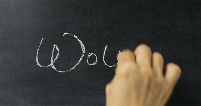 Hand writing Wow! on chalkboard 