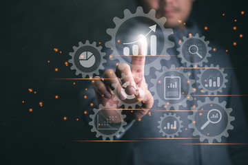Business data analytics process management with a consultant touching connected gear cogs with KPI financial charts and graph, automated marketing dashboard