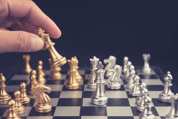 hand of businessman moving chess figure in competition success play. strategy, management or...