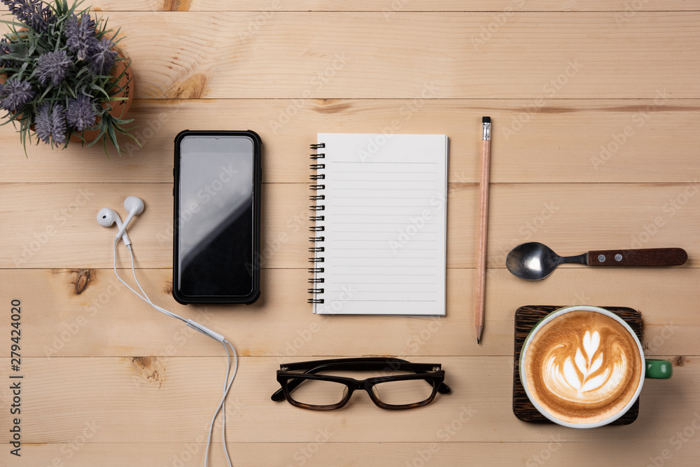 Aufkleber Notebook Blank, notebook with pencil  and smart phone on wooden background.,cup of coffee latte.