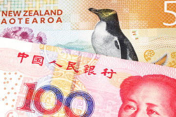A colorful five dollar bill from New Zealand, close up in macro with a red, Chinese, one hundred yuan renminbi bank note