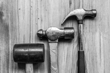 Different types of hammers on wooden background