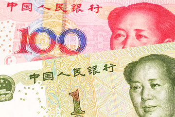 A close up image of a one yuan note from the People's Republic of China along with a red, one hundred yuan note from China