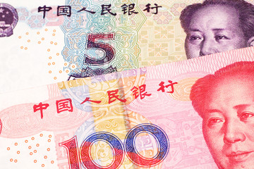 A close up image of a five yuan note from the People's Republic of China along with a red, one hundred yuan note from China