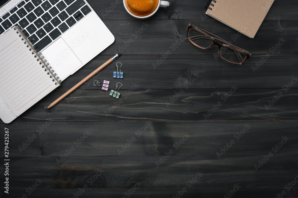 Poster modern dark wood office desk table with laptop, smartphone and other supplies with cup of coffee. co