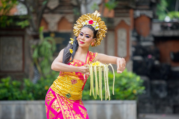 Beautiful dancer dances with a bowl of flower petals
