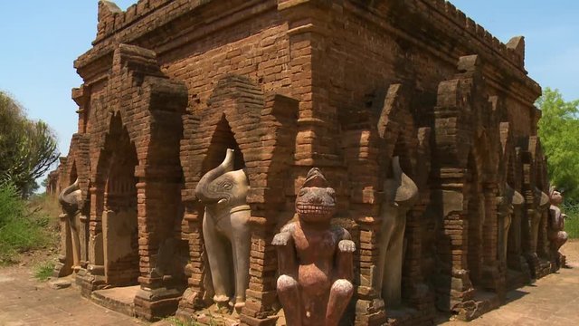 A close up shot of statues of elephants and other animals surrounding an ancient building