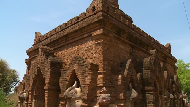 A close up shot of statues of elephants and other animals surrounding an ancient building