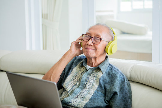 Happy Old Man Enjoying Music With Headphones