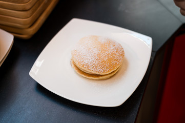 three pancakes with banana in white dish