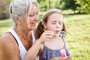 Grandmother and child blowing bubbles