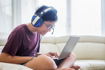 Young preteen boy plays online games on laptop