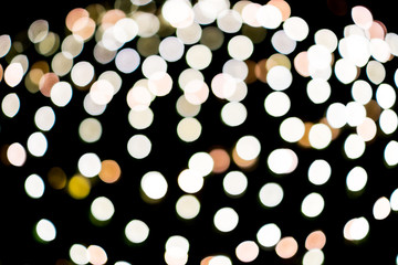 Abstract white yellow bokeh lights on road street in city night light background, decoration in soft for greeting card backdrop with glitter sparkle blurred circles