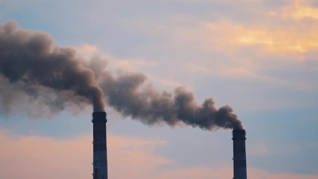 Air pollution in smoke from pipes of metallurgy plant. Massive air pollution filling the sky creating a toxic environment affecting life. Ecological disaster.