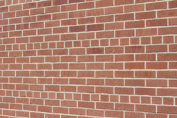 Fototapeta premium Modern brown color brick wall background with weathered rough texture bricks in a common bond brickwork pattern (angle view)