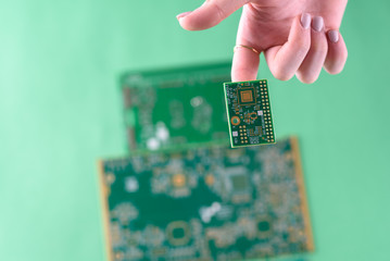 Small Electronics Circuit Boards on Human Woman Finger. Female Technician Inspecting Defective Circuit Board.