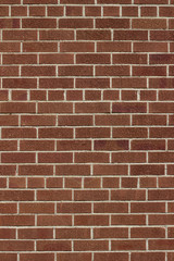 Modern brown color brick wall background with weathered rough texture bricks in a common bond brickwork pattern