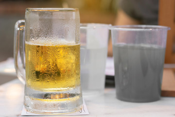 Close up of the cold glass beer with froth in pub & restaurant background.