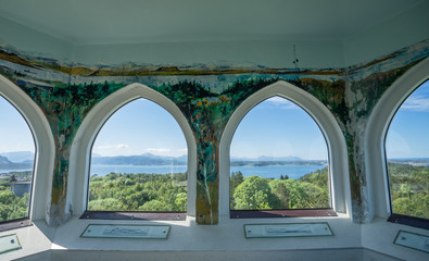 Obraz premium Kristiansund / Norway - June 15 2019: Interior of the Varden viewpoint, the highest point on Kirkelandet. Decorated wall inside, 360 degrees view via arched windows on surrounding mountains and fjord.