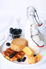 Viennese waffles, cheese and milk bottles on a white plate. Breakfast concept. View from above.