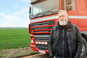 Portrait of mature driver at modern truck outdoors. Space for text
