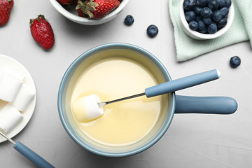 Flat lay composition with white chocolate fondue on light background