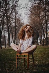 Curly beautiful girl, portrait on the street, autumn yellow leaves.