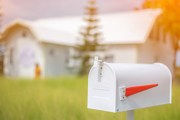 White mailbox in front of house background during early morning light