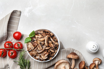 Flat lay composition with delicious cooked mushrooms on white marble table. Space for text