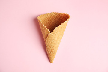 Empty wafer ice cream cone on pink background, top view