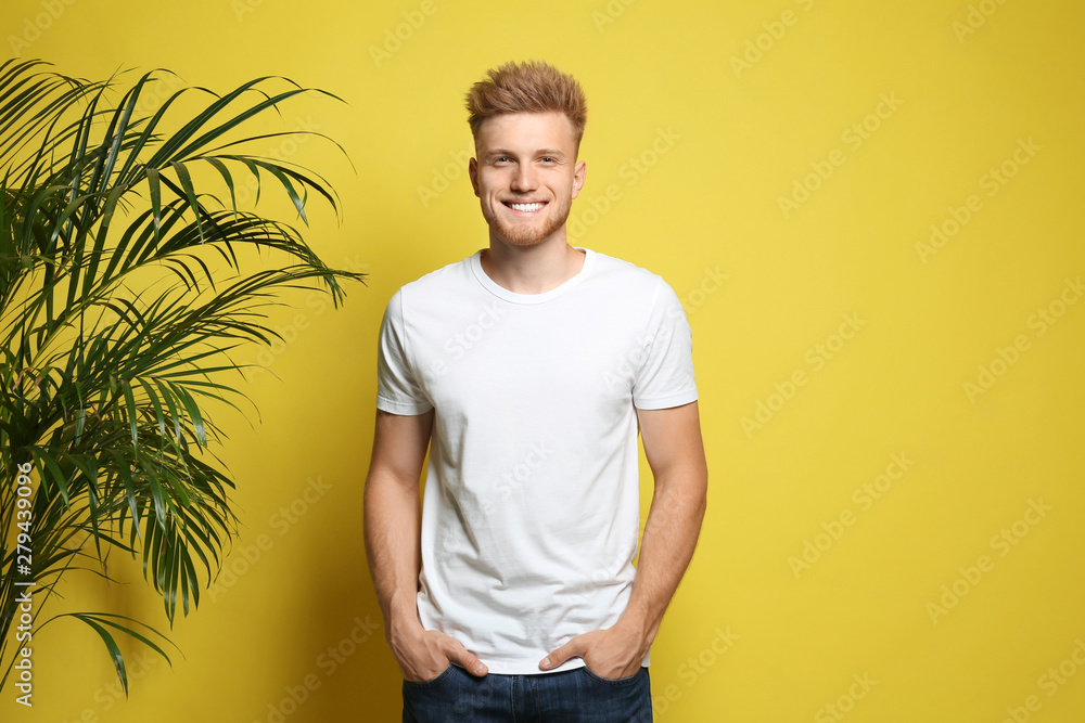 Poster Young man wearing blank t-shirt on yellow background. Mockup for design