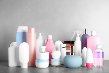 Different body care products on table against grey background