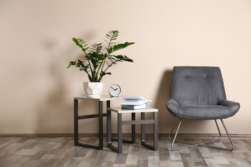 Stylish room interior with comfortable chair near color wall