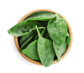 Fresh green healthy baby spinach leaves in wooden bowl isolated on white, top view
