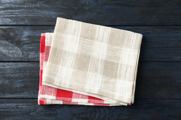 Different checkered kitchen towels on blue wooden table, top view