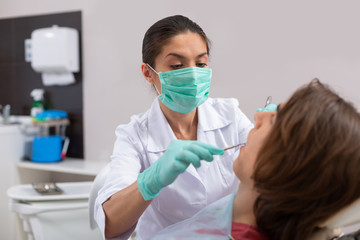 Doctor examining the oral cavity of a teenager