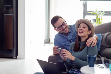 Young couple sitting and shopping online with laptop and credit card on hand