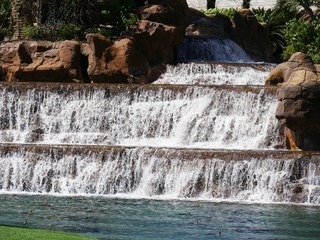 Close up of water cascading down a waterfalls in a landscaped garden
