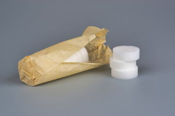 Hexamine Solid Fuel wrapped in paper on gray background