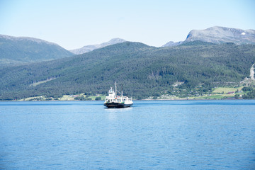 Fototapeta na wymiar Molde / Norway - June 15 2019: Ferry that operates on European route E39 between Molde and Vestnes transporting cars and people over the Midfjorden fjord. Europe