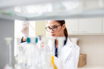 Young woman working in laboratory on some experiment